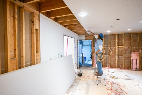 Drywall installers working in kitchen renovation.